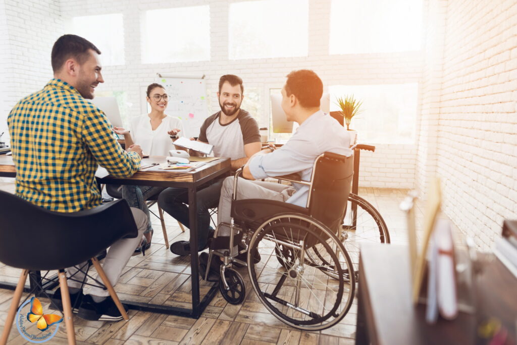 A man in a wheelchair communicates cheerfully with employees of the office during a business meeting. مردی روی صندلی چرخدار با لبخند به همکاران خود خوشامد می گوید